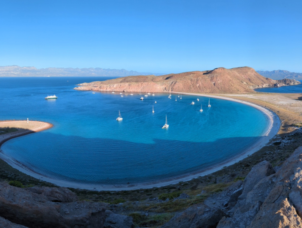 Sea-of-cortez-anchorage Sailboats anchored in a serene turquoise bay with scenic mountains and sandy beaches, perfect for sailing adventures.